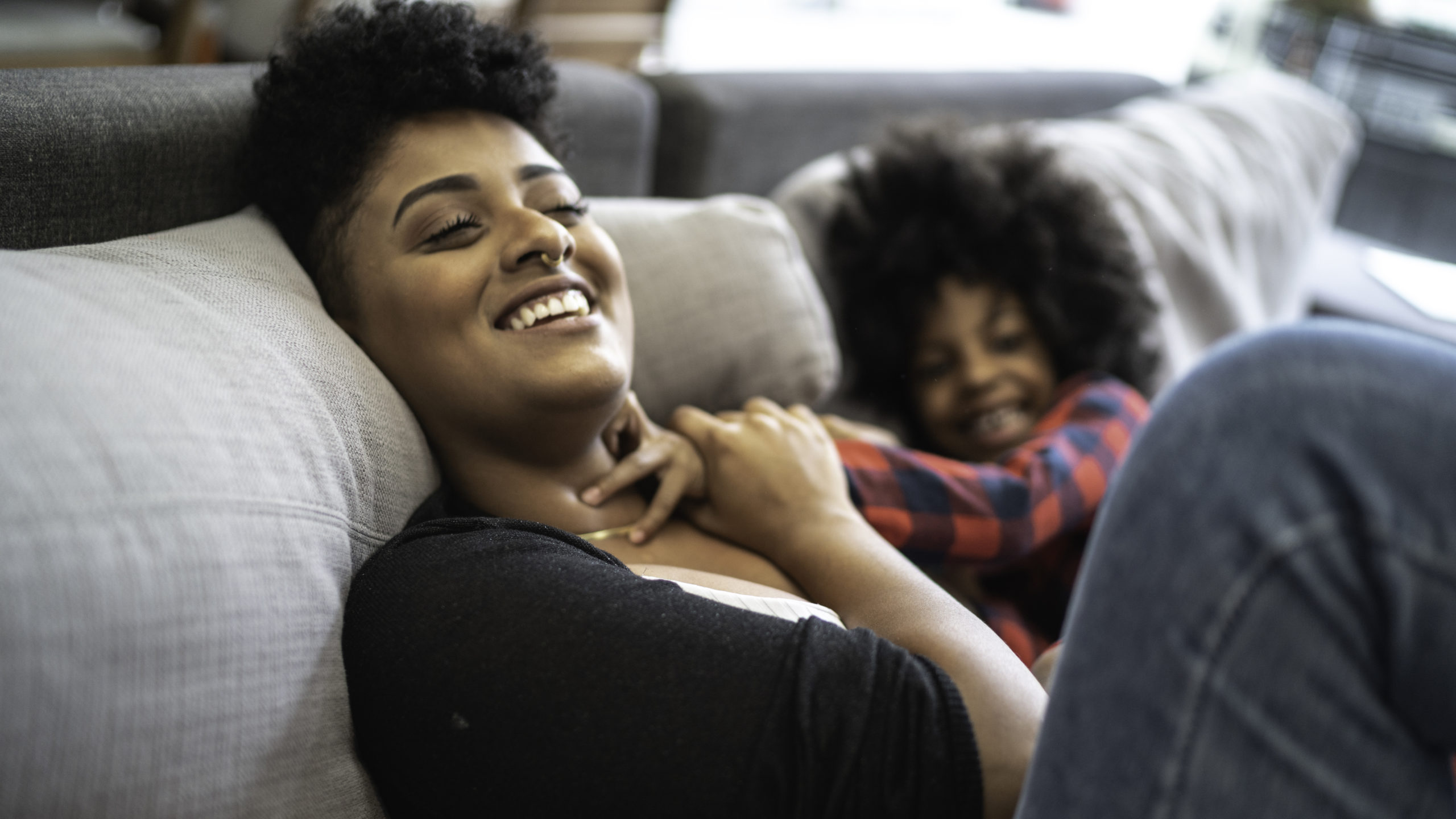 mom playing with child on couch