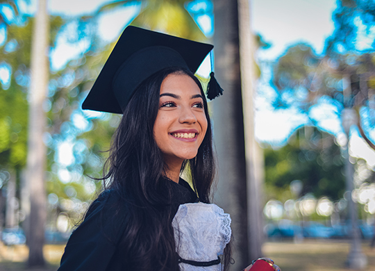 A young woman wearing a cap and gown